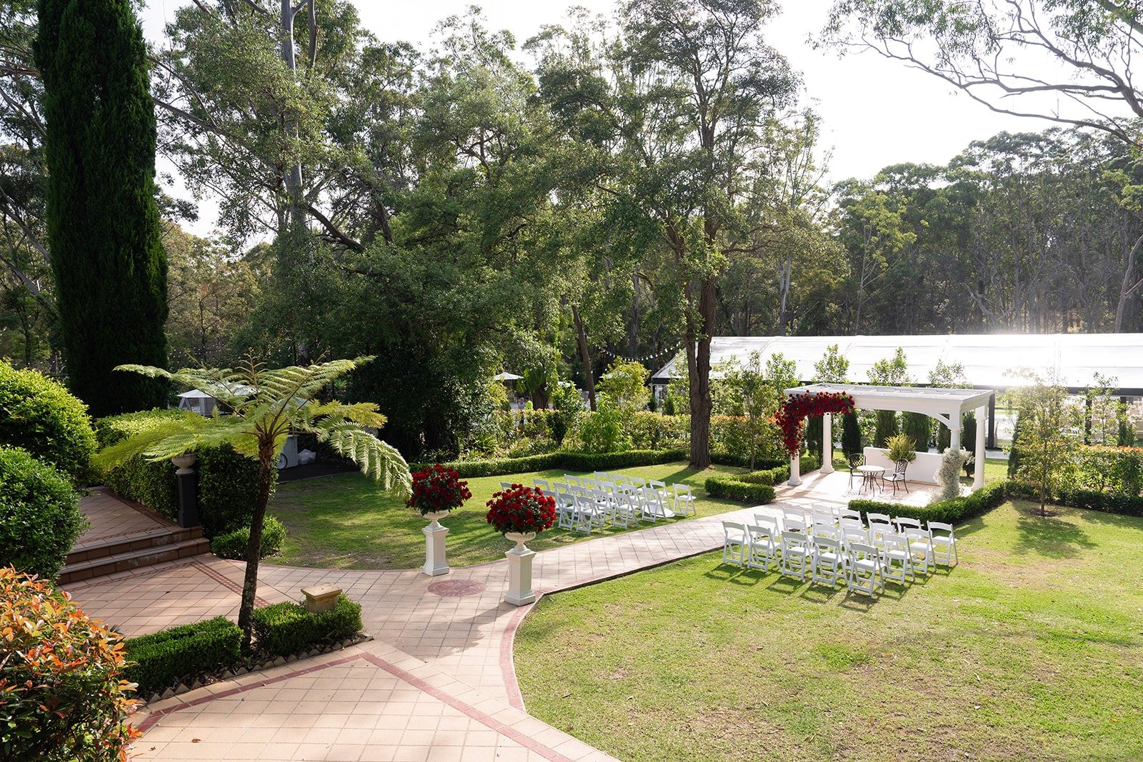 The ceremony gardens set with white chairs along a paved aisle to the gazebo