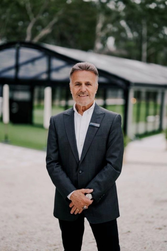 Frank Anisse, Managing Director, in a dark suit in front of The Pavilion